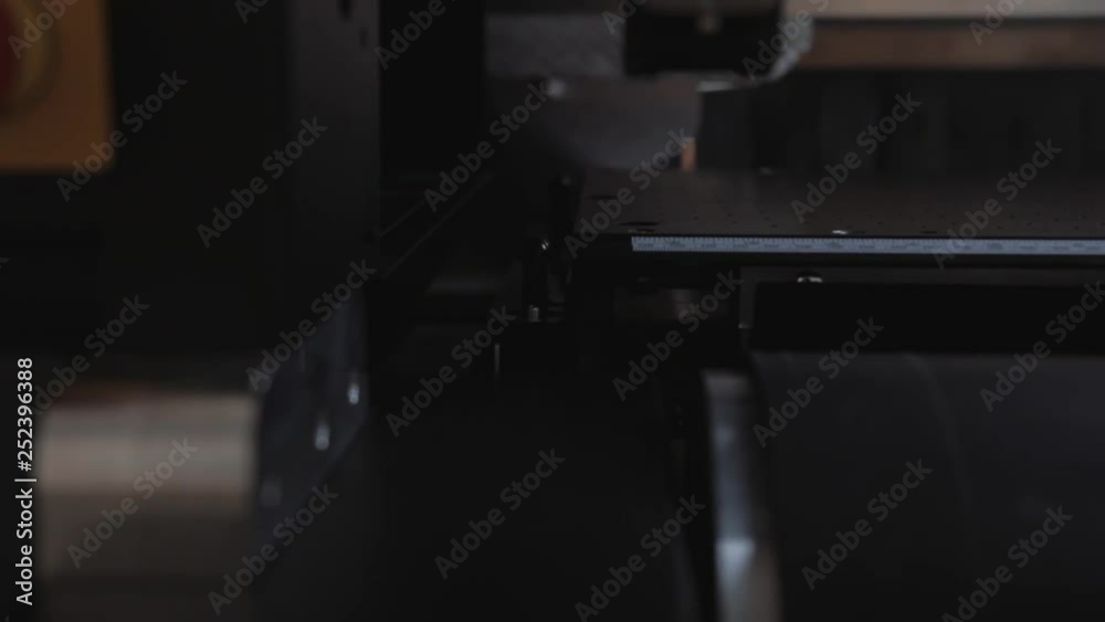 Professional printing facility, big vinyl rolls, ready for large printer supply. Glossy, matte, ecological paper tubes. Detail of massive printhead passing by with purple flashes. Professional printing facility, big vinyl rolls, ready for large printer supply. Glossy, matte, ecological paper tubes. Detail of massive printhead passing by with purple flashes.