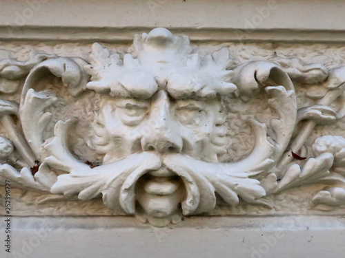 snot-nosed sculpture of a man's head on the facade of an old house