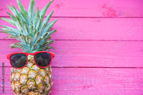 Holiday pineapple have sunglasses on pink   wooden background