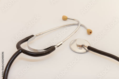 stethoscope with a black tube lies on a white background