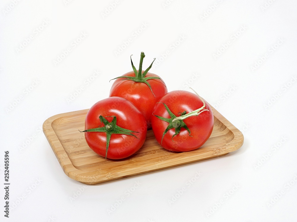 Tomatoes, bush tomato with stalk on a wooden board Tomatoes, bush tomato with stalk on a wooden board