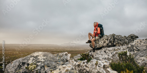 Woman hiker sitting on a hill relaxing