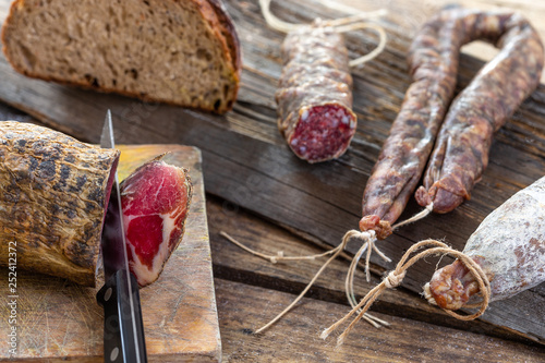 Local wild pork meat , delicatessen, made Corsica France wooden background
