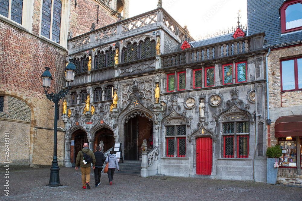 Fototapeta premium Front of an old house with tourists in the historic centre of Bruges