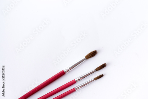 close up of paint brushes isolated on white background. table for paint. text