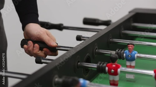 Close up of table football kicker game. Two young co workers play table football game as an active break to relax and have rest during busy and hardworking business day in the office