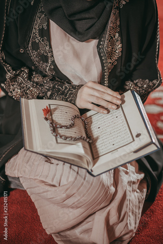 Young muslim girl reading a holy book