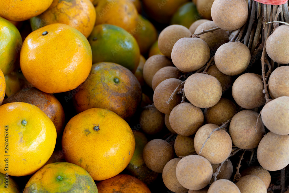 The orange and Longan fruit piles are arranged in order for market.