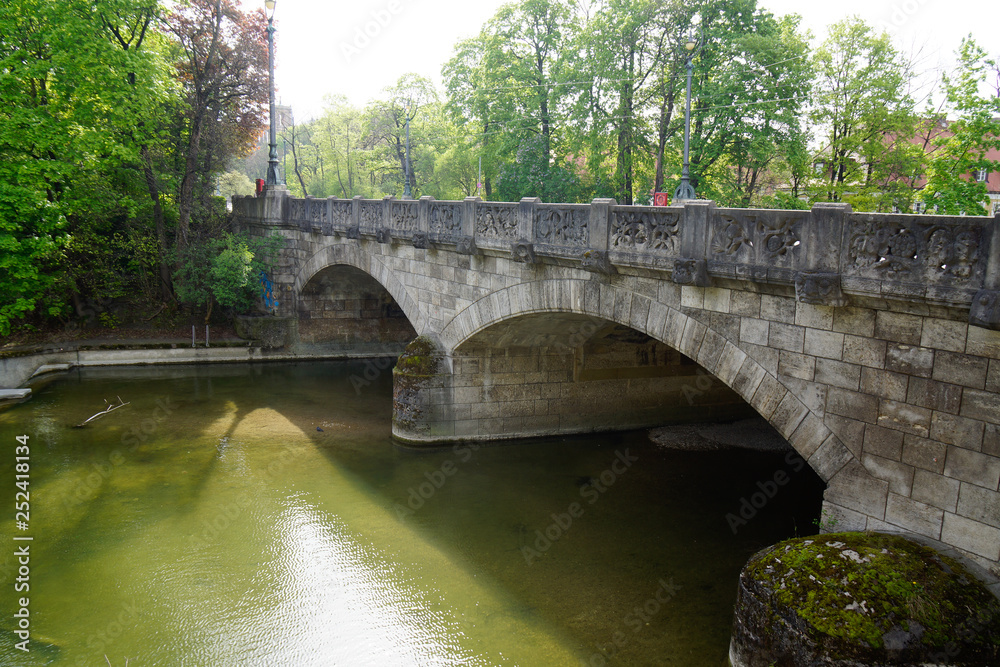 Fototapeta premium old stone bridge with trees over isar river in bavaria