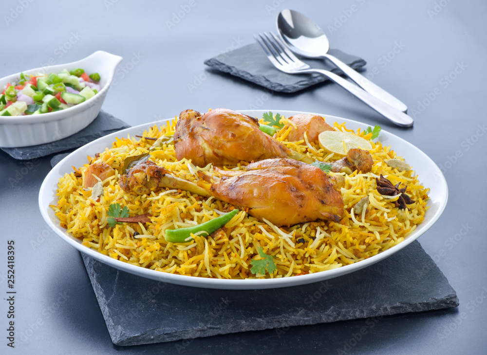 Chicken Biryani, a yummy & fluffy rice dish with spicy savory chicken pieces with salad. Chicken Biryani, a yummy & fluffy rice dish with spicy savory chicken pieces with salad.
