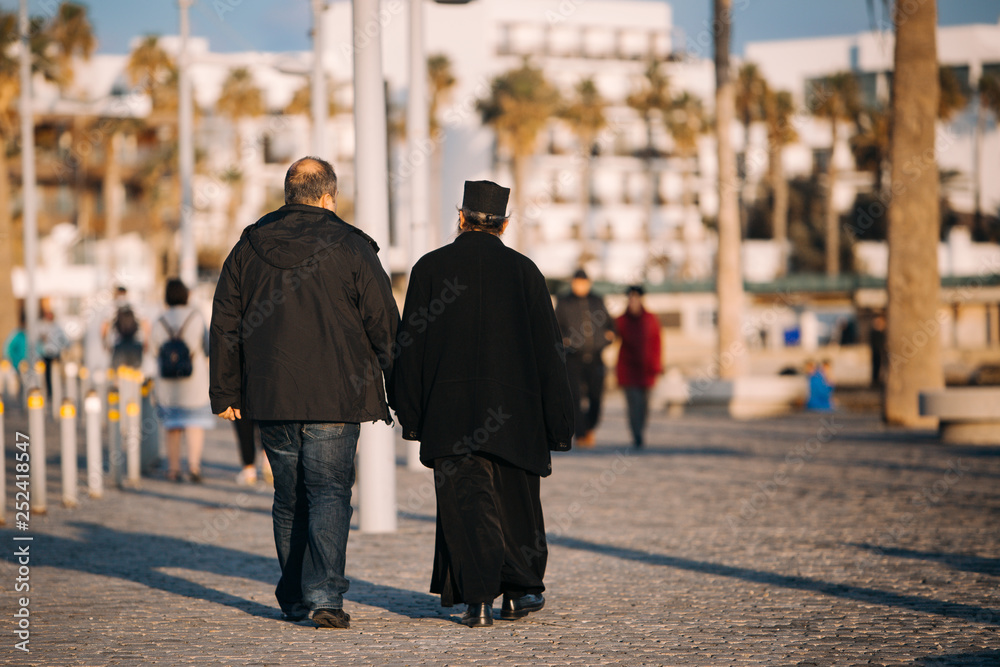 Two local mans is walking at the Paphos promenade