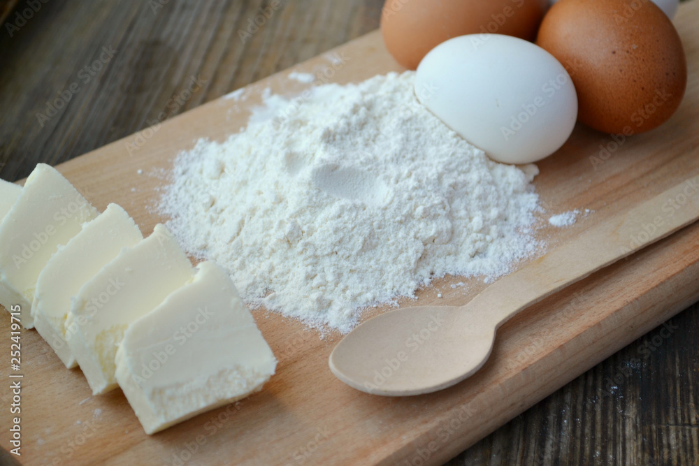 White flour with eggs on a cooking board White flour with eggs on a cooking board