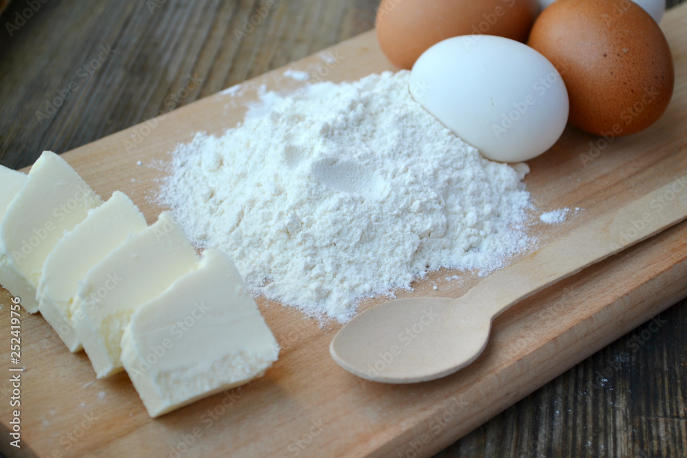White flour with eggs on a cooking board White flour with eggs on a cooking board