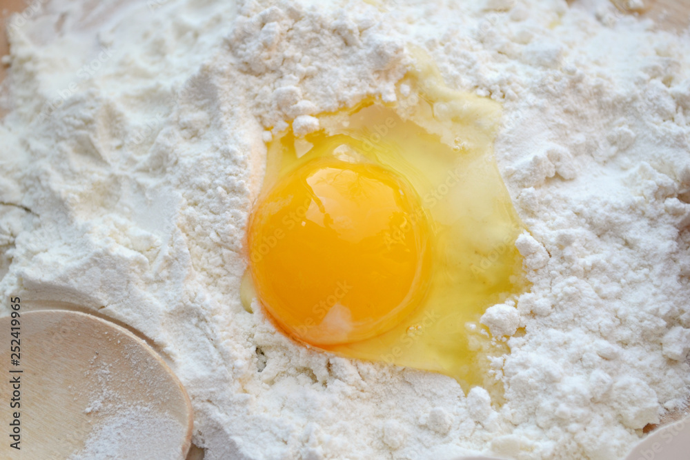 White flour with eggs on a cooking board White flour with eggs on a cooking board