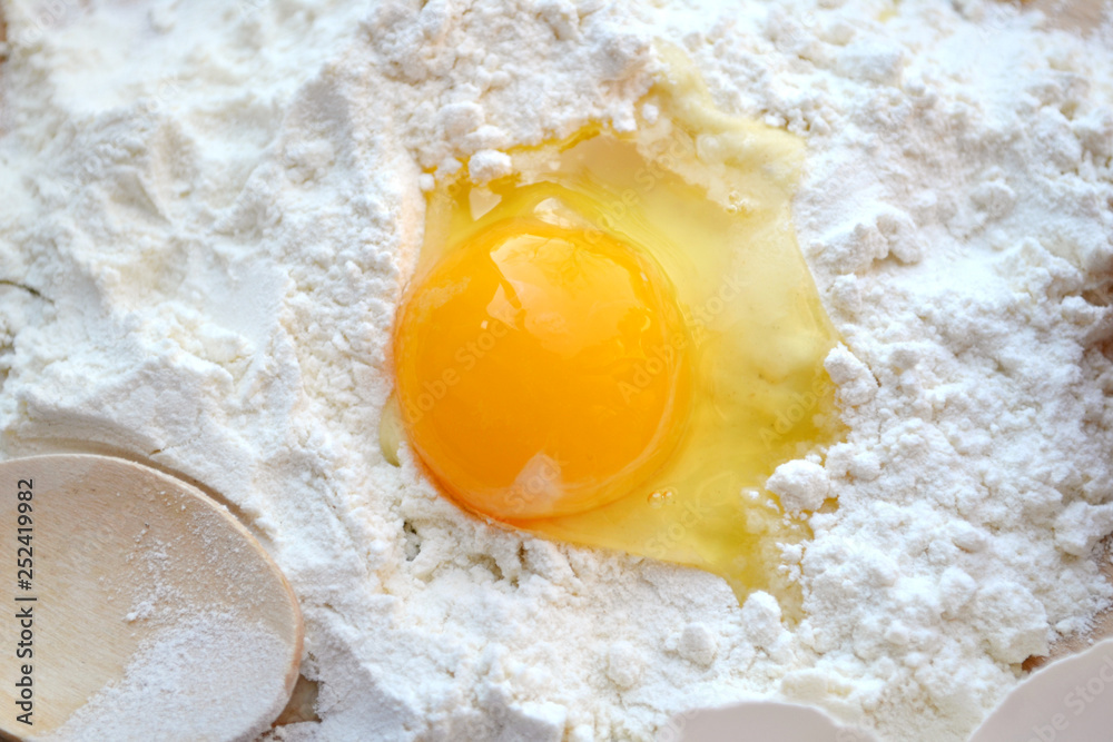White flour with eggs on a cooking board White flour with eggs on a cooking board