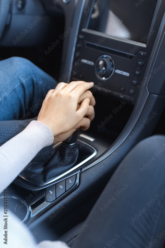Couple holding their hands together on transmission gearbox in a car