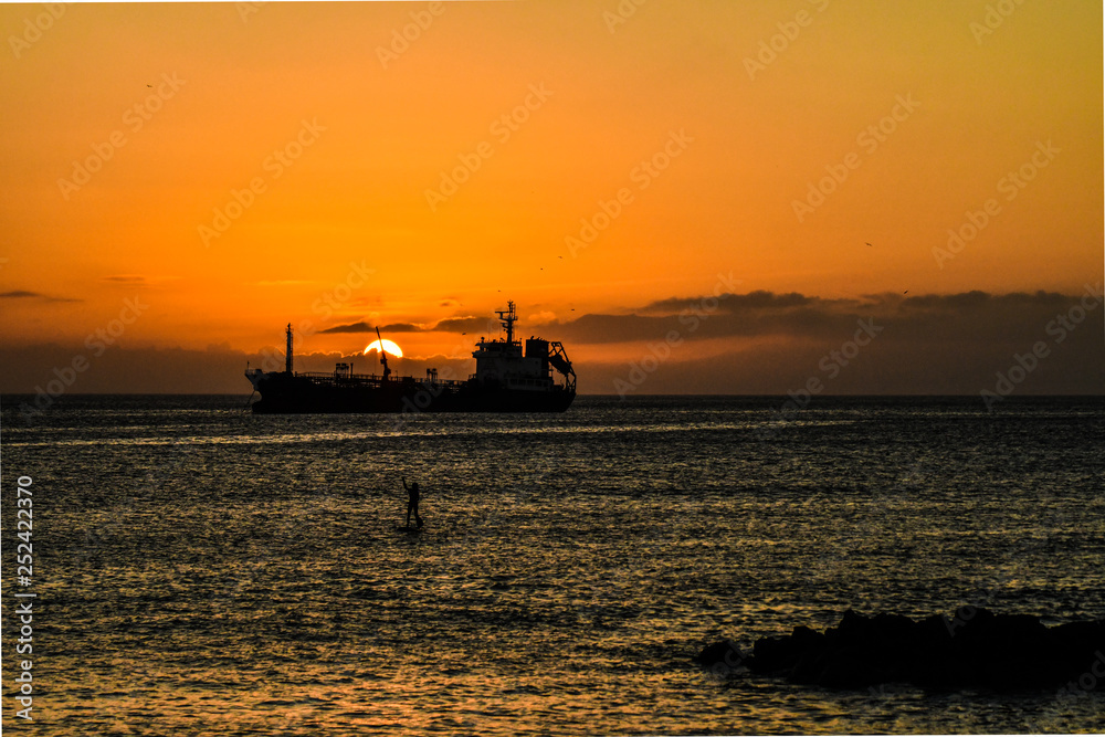 Ship with stand up paddle in sunset