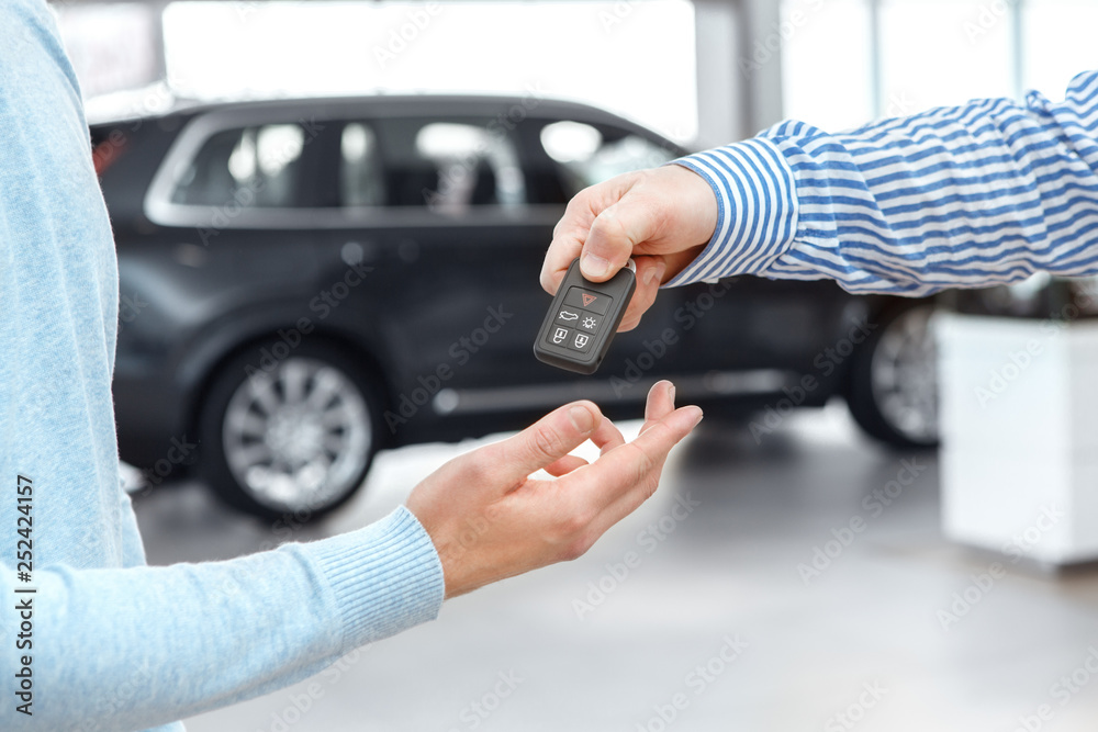 Handsome young man buying car from a professional dealer Handsome young man buying car from a professional dealer