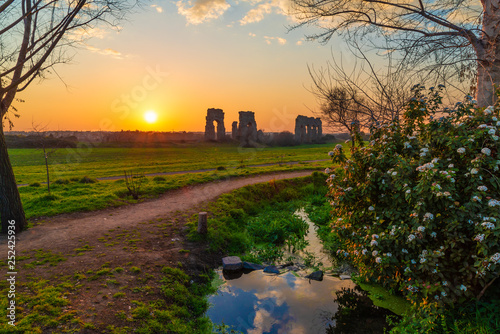 Rome (Italy) - The Parco degli Acquedotti at sunset, an archeological public park in Rome, part of the Appian Way Regional Park, with monumental ruins of roman aqueducts. photo