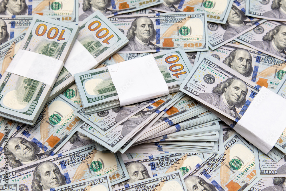 One hundred dollar bills on the table as background One hundred dollar bills on the table as background