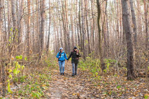 adventure  travel  tourism  hike and people concept - smiling couple walking with backpacks over autumn natural background