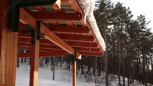 Melting Icicles dripping off a roof. Spring drops, icicles are melting sun and snow. spring in the ski resort