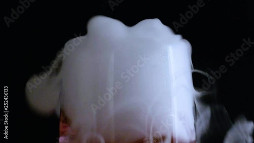 Bubbling smoking champagne flute turns from clear to red liquid