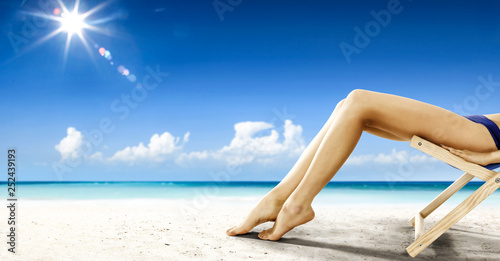Slim young woman legs and beach background 