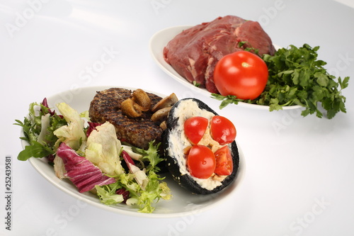 cheeseburger with black bread, beef cutlet, bacon, tomatoes and cheese slices, seasoned with sauce and green salad for a restaurant menu on a white isolated background