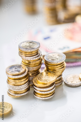 Euro banknotes and coins togetger on white table - close-up photo