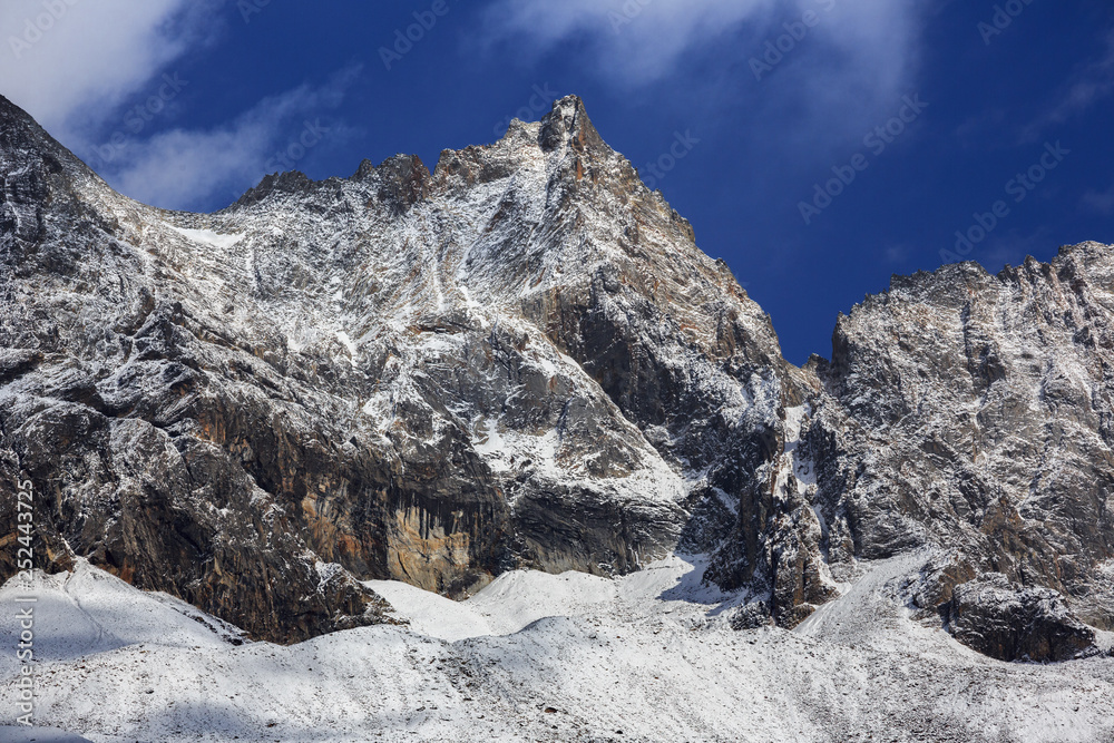 Four Girls Mountain National Park in Sichuan Province, China. ShuangQiao Valley Scenic Area, Snow Capped Jagged Mountains with clouds forming at the summit. Blue Sky, Snow Mountains, Siguniangshan