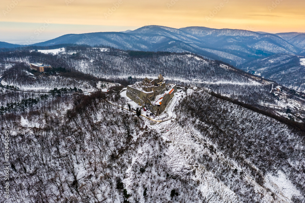 Visegrad, Hungary - Aerial panoramic view of the beautiful old and snowy high castle of Visegrad at sunrise on a winter morning with the hills of Pilis at background