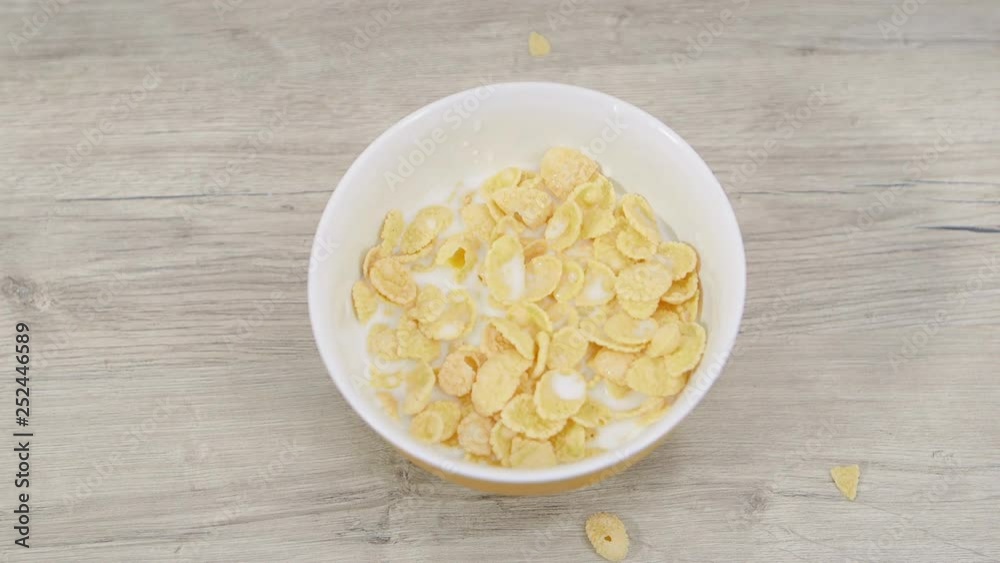 Preparation of breakfast cereal with milk in a bowl on a wooden table. Top view. Preparation of breakfast cereal with milk in a bowl on a wooden table. Top view.
