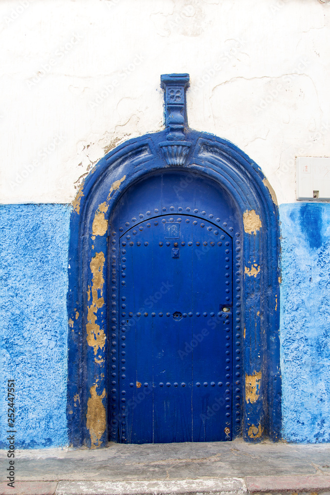 Traditional moroccan door with arch form painted with blue in Meknes, Morocco
