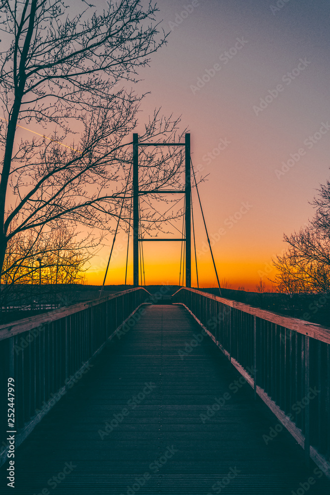 Obraz premium Low angle view of a silhouetted bridge at sunset