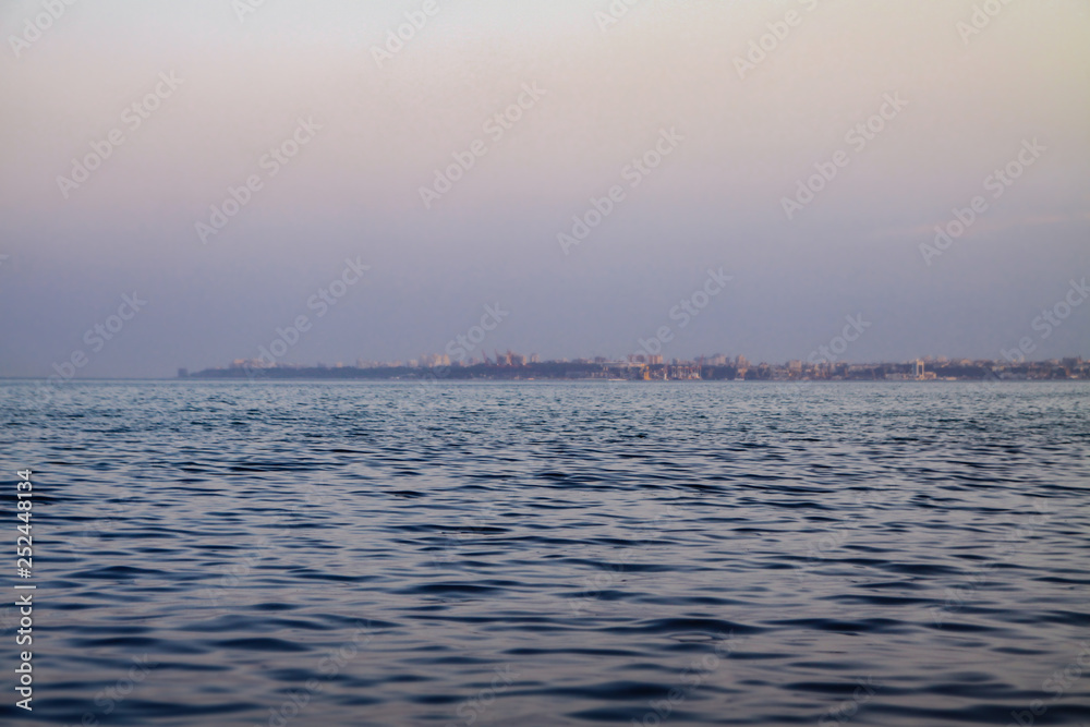 Evening sea on the background of the city. Beautiful landscape for design Evening sea on the background of the city. Beautiful landscape for design