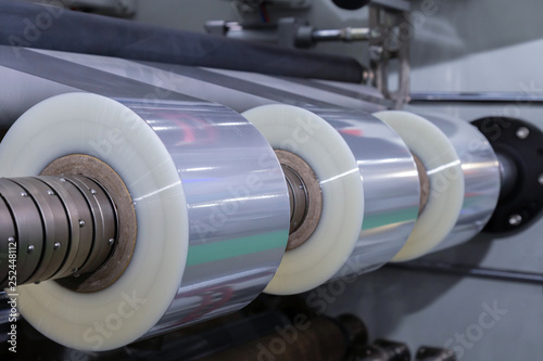 roll of plastic packaging film on the automatic packing machine in food product factory. industrial and technology concept.