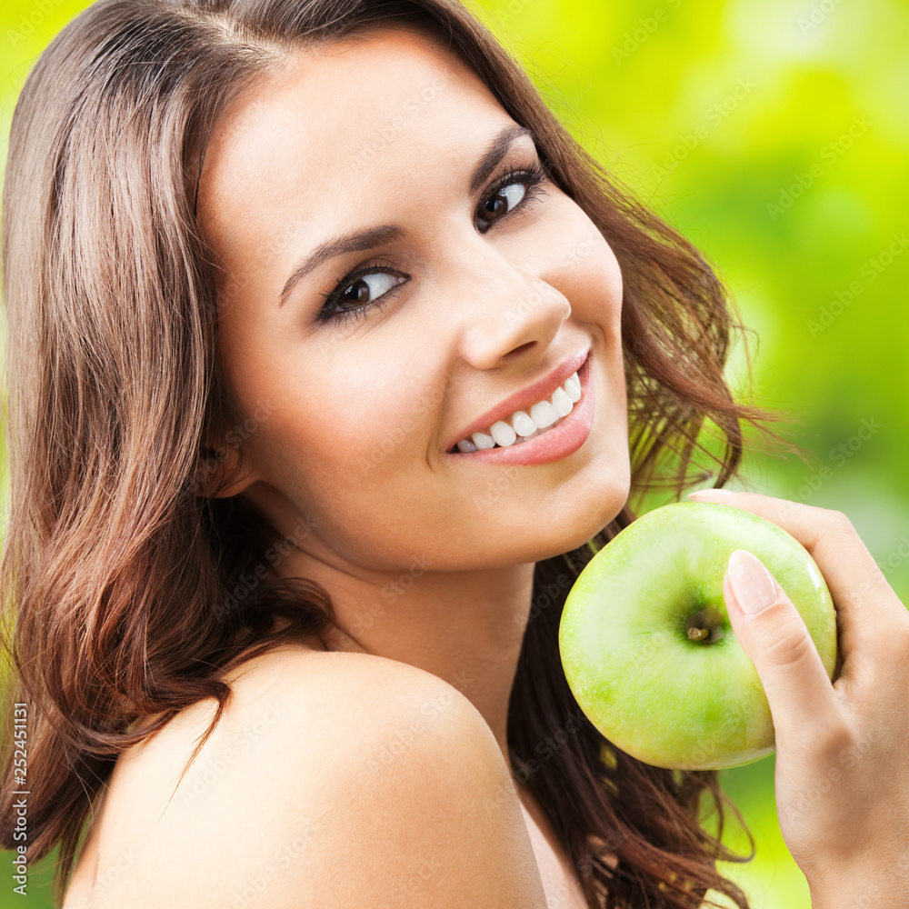 Young happy smiling woman with apple, outdoors Young happy smiling woman with apple, outdoors