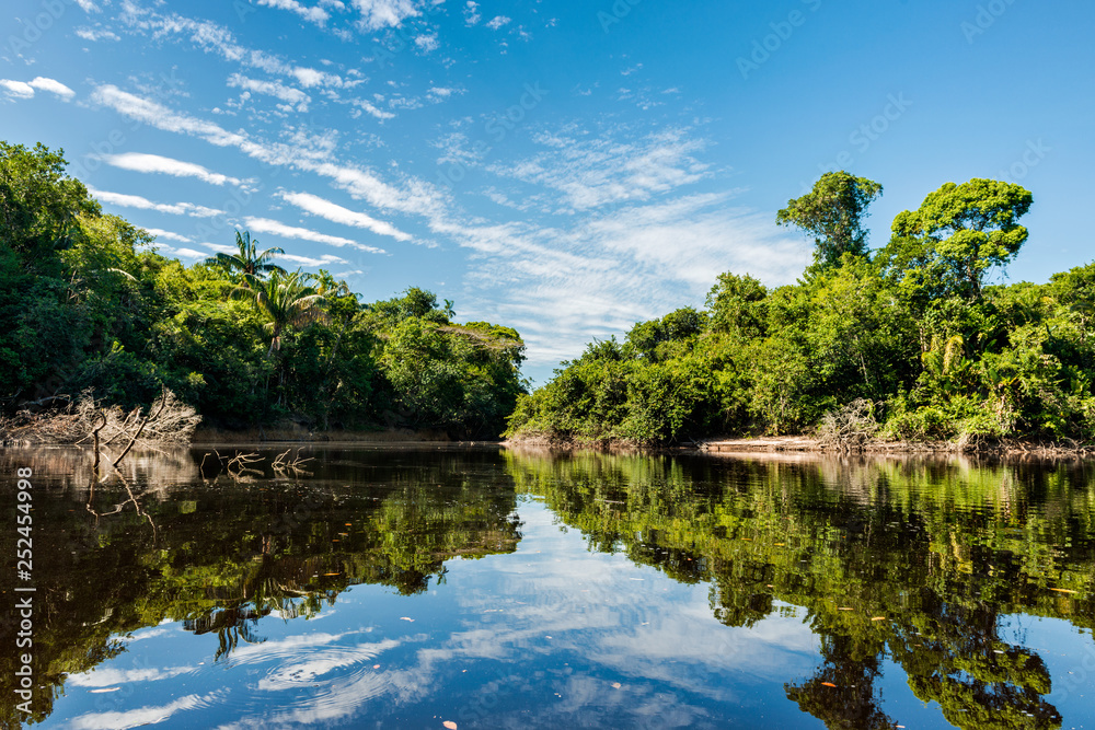 Beautiful blue sky reflecting in the Amazonia Basin river. Corocoro river goes along Yutaje Community whicth mean in the native language: River Foam (Espuma del Rio) Beautiful blue sky reflecting in the Amazonia Basin river. Corocoro river goes along Yutaje Community whicth mean in the native language: River Foam (Espuma del Rio)