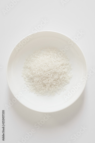 one white plate with rice in the center on a light background. Space to copy the inscriptions and design