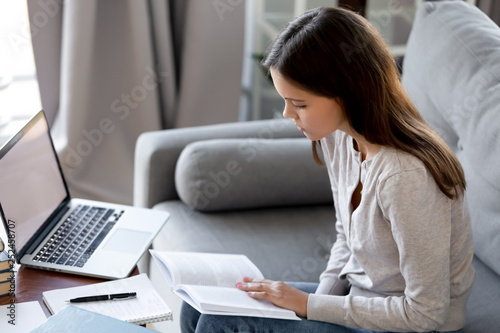 Serious young woman preparing to passing exam or doing homework