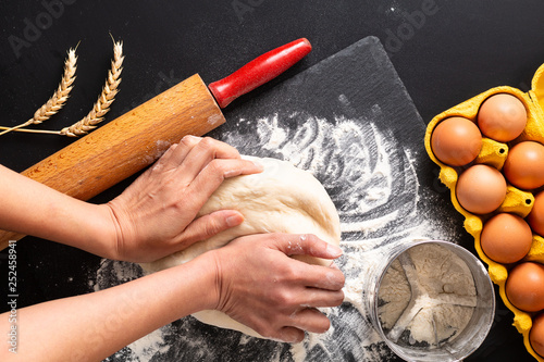 Food preparation concept over head shot Kneading dough for bakery, pizza or pasta on black background with copy space