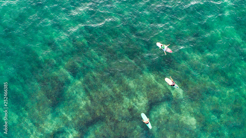Photography top view of Three Surfers are waiting for waves in the ocean in sri lanka
