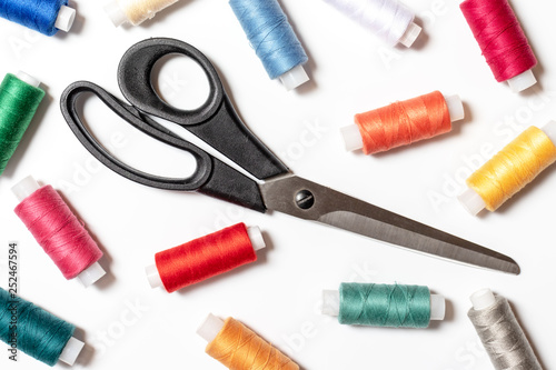 Colored thread coils and scissors on white background, sewing, handmade and DIY concept - design for seamstress and tailor articles and blog illustration