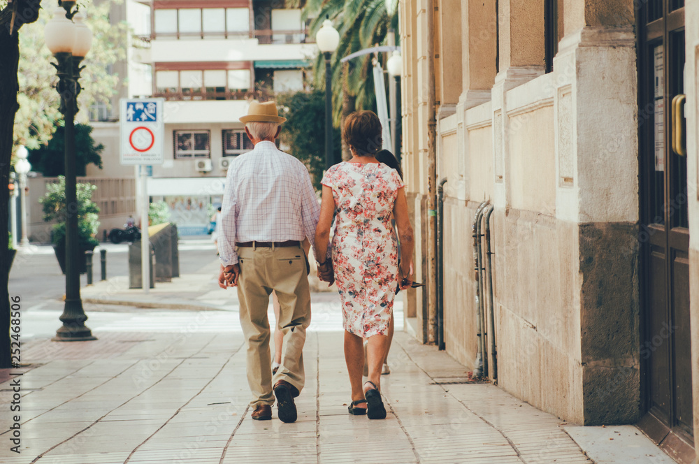 elderly couple walking the streets of Spain holding hands