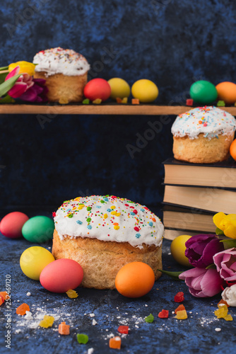 Easter food.Colorful eggs,delicious cakes on a blue background.Holiday composition.