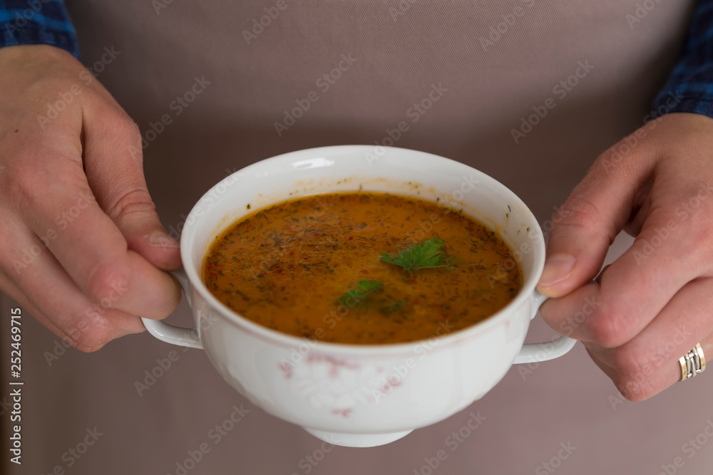 the Tarhana soup in the bowl that the woman hold it for kitchen and food concept. 