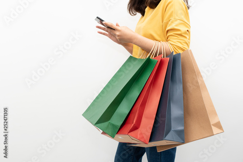 woman holding shopping bags and used smart phone, shopping concept
