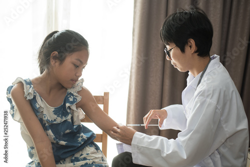 doctor injecting vaccine to child