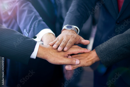 Group of hispanic business man joining hands in suits, team work concept